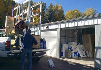 Verne and John Boy Delaney load siding into the longer bed of the white pickup when clearing out the Osburn warehouse.