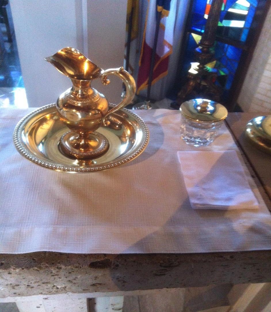 ONE SERVER PICKS UP THE PITCHER AND BOWL; THE OTHER SERVER HOLDS THE TOWEL