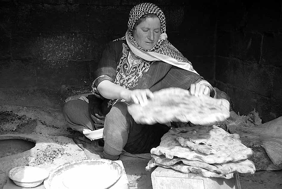 Um Hani, a Palestinian mother, bakes bread (taboun), the main sustenance for her family.