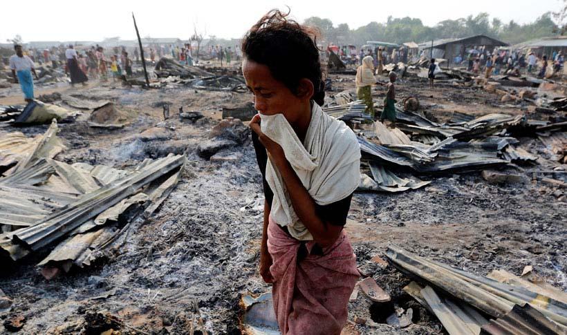 A woman walks among debris after fire destroyed shelters at a camp for internally displaced Rohingya Muslims in the western Rakhine State near Sittwe, Myanmar May 3, 2016.