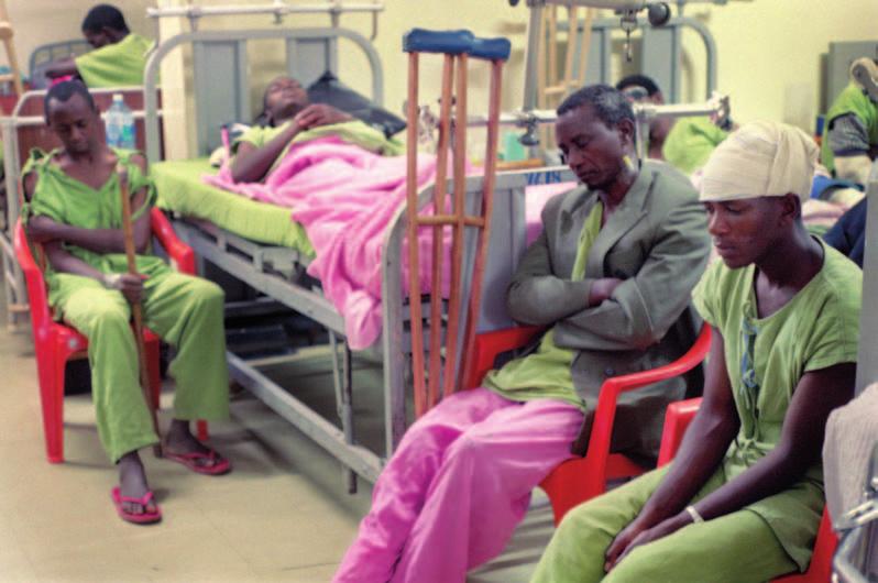 Kenya Men at Kijabe Hospital bow their heads for prayer during a visit by the hospital s chaplains and the CC Delaware County team. Nancy Gauzza handed out prescriptions through the church window.