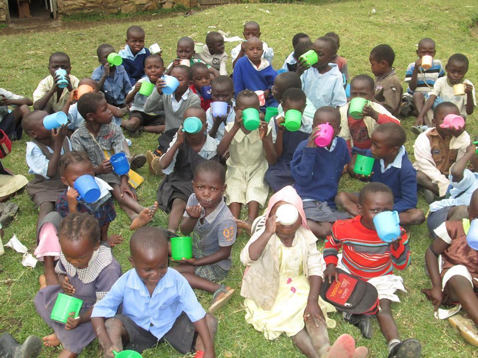 School children having something to drink at lunchtime. The ministry helps with shoes, uniforms, clothes, stationery, medicine and salaries for teachers and other workers.