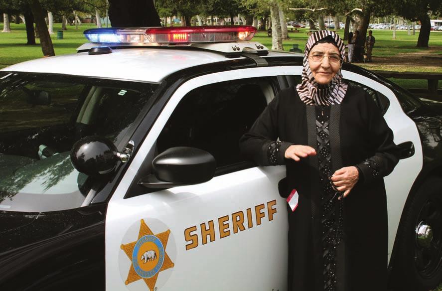 Photo on left:a grandmother from a local Muslim community visits the LASD Muslim Community Affairs Unit booth at a family picnic celebrating Eid el Um (Mother s Day).