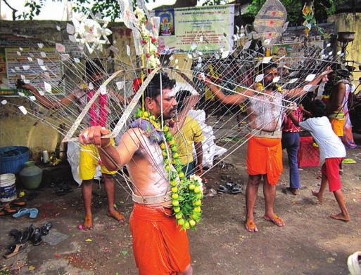 Amman devotees with spears piercing their bodies and phone 92831 03990 and 90803 hanging by hooks from poles going in procession along 47461.