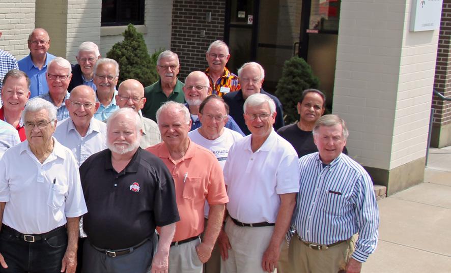 Priests who preach on behalf of Unbound gather in front of the organization s Kansas City headquarters in August. They came from all across the U.S. for their annual conference.