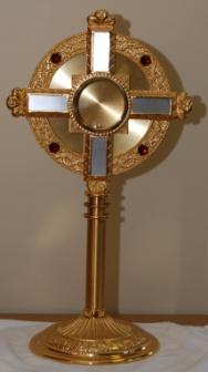 Luna (lunette) A special pyx made of gold with two glass faces which is used for holding the Host in an upright position and inserted into the monstrance when exposed for