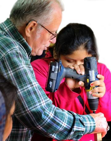 Page 8 TOP: Mentor Paul Gilstrap teaches a youth how to use a power drill. ABOVE: Becky Hughes helps with the leathercraft, which was lead by IMNA Founder, James Hughes.