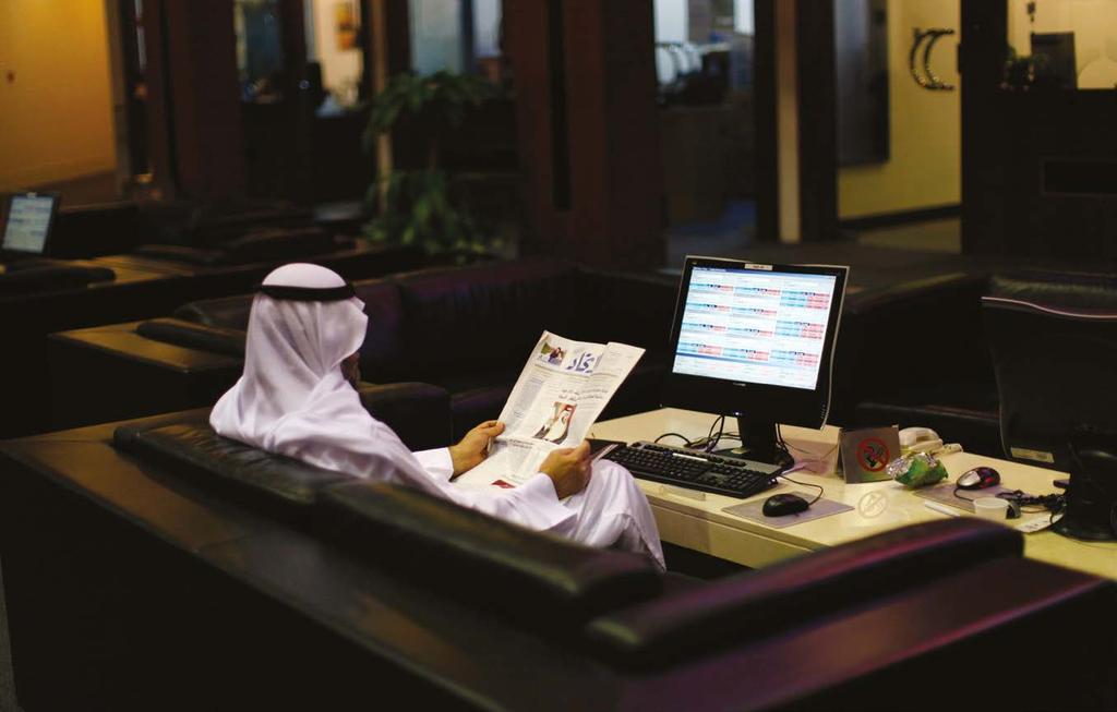 Awareness Indicator CONFERENCES An investor reads a paper as he monitors a stock exchange information