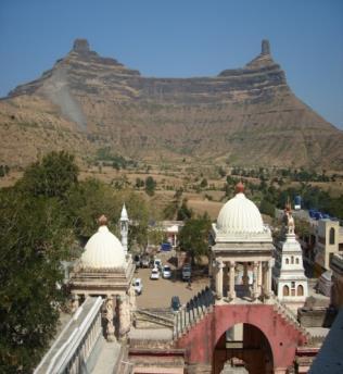 Nashik district. Temple complex has dharmashala, temples, shops, office. The Siddha Kshetra has 15 temples together on both peaks and is climbed by 3500 steps.