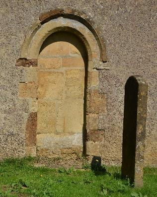 lower rounded arch fronted the chancel, standing between the two stone capitals you can still see behind the present arch.