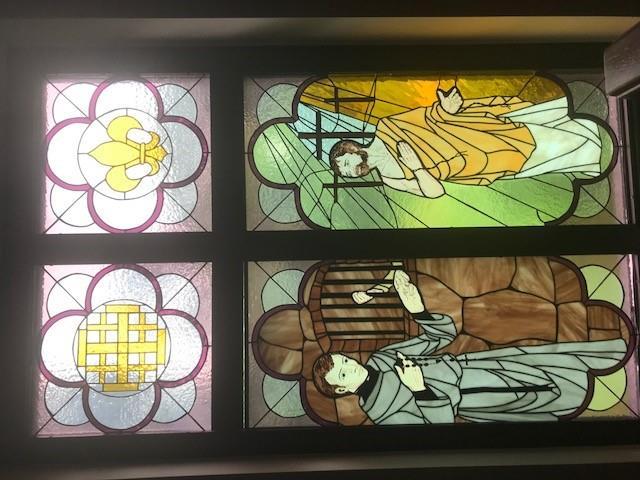 The first window on the right represents the Corporal work of Mercy: Visit the Imprisoned. St. Joseph Cafasso is the patron of the imprisoned.