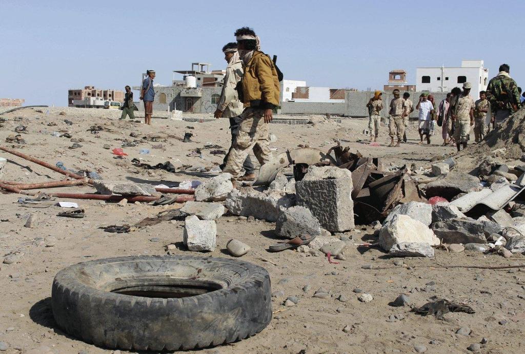 Soldiers gather at the site of a suicide attack at a base in the southern city of Aden, Yemen, on 18 December 2016.