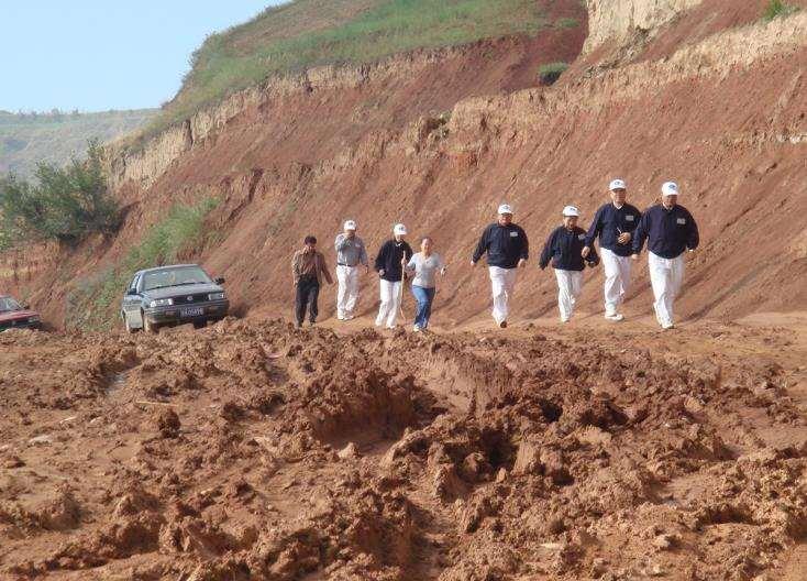 Tzu Chi volunteers survey the drought in order to build water cisterns in Gansu Province, China A torrential rainfall caused the road to become muddy when Tzu Chi volunteers went to Hongquan town