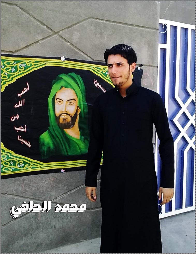 Figure 5: Muhammed Helfi stands in front of a picture of Husayn, one of the most important figures in Shia Islam.