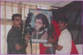 9 Two Fatah-Tanzim operatives in Ramallah carry a picture of Hezbollah leader Hassan Nasrallah.