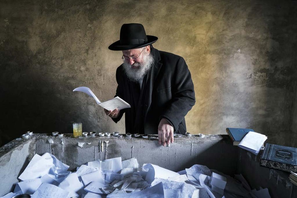 Yitz Twersky praying and crying over the tomb of his ancestor and founder of