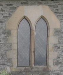 A rudimentary form of bar tracery, although strictly neither plate nor bar tracery. Hood mould terminates at the springing point of the arch with short horizontal returns at either side.