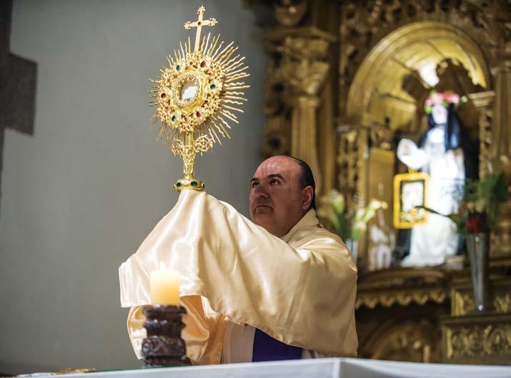 Adrian holds the monstrance, as he recites a joyful benediction to