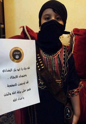 A photo released on a jihadi forum as part of the same set as the ISIS cake above. A young Saudi girl holds a placard with ISIS insignia.
