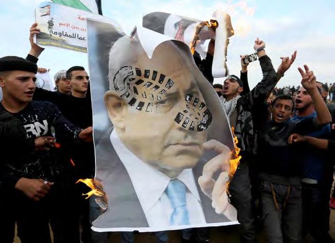 Demonstrators step on a picture of former Defense Minister Avigdor Lieberman,
