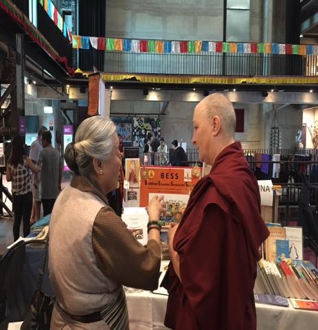 The picture shows Ama Jetsun Pema visiting our stall and talking animatedly to Venerable Tseten about teaching the Dharma in western schools.