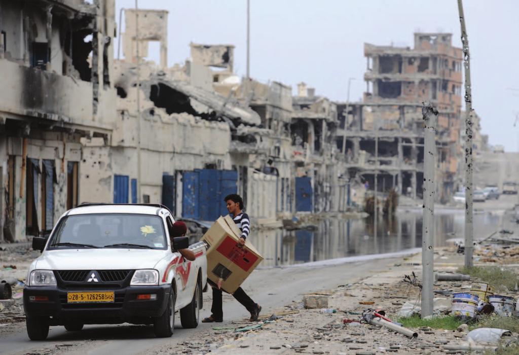 Libyans load their belongings into a car in a destroyed neighbourhood in Sirte.