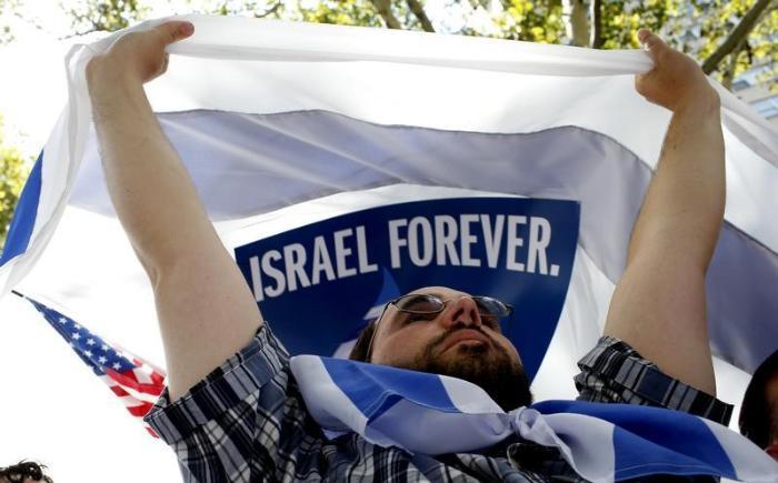 (Credit: REUTERS) A man holds up an Israeli flag during a pro-israeli demonstration near the United Nations in midtown Manhattan in