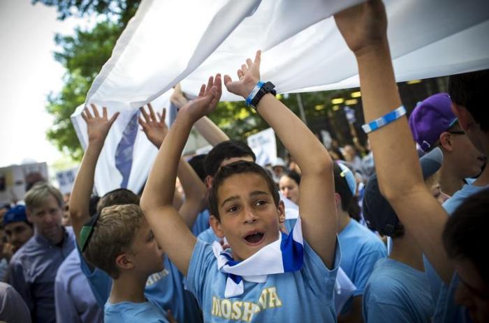 Children from a Hebrew summer camp carry an Israeli flag during a pro-israeli demonstration near the United Nations in midtown Manhattan in