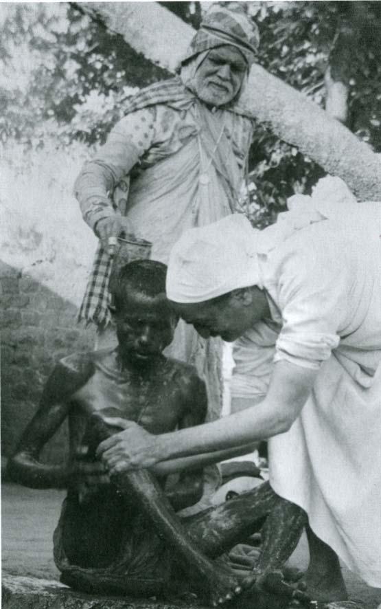 Meher Baba bathing a leper in
