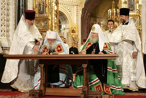 Signing of the Act of Canonical Communion. Behind Metropolitan Laurus and Patriarch Alexy II are Fr Alexander Lebedeff and Fr Nikolai Balashov.