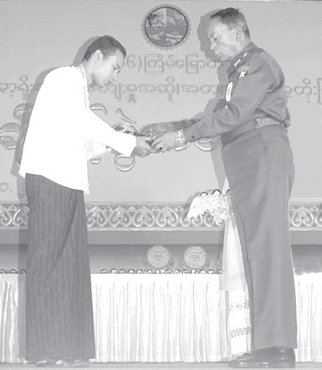 Minister for Cooperatives Maj-Gen Tin Htut presented prizes to the winners in the donmin contests: U Kyaw Htay of Magway Division who stood first in the amateur level (first class) men s contest, U