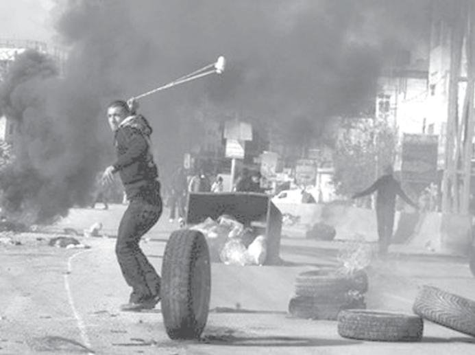 A Palestinian protestor hurls a stone at Israeli soldiers during a demonstration at the Qalandia Israeli checkpoint on the outskirts of the West Bank city of Ramallah.
