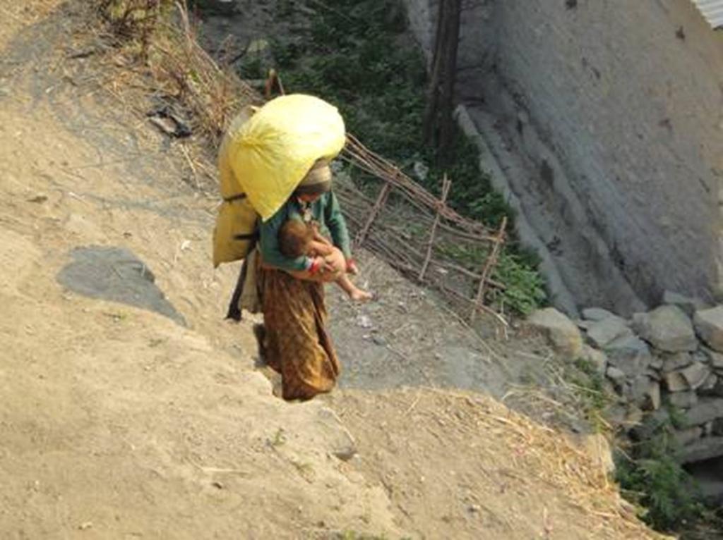 This woman is from the Mugu District of Nepal. On top of carrying her child she is carrying over 50kg of cargo via a strap on her head.