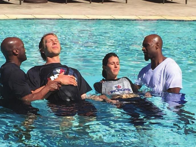 Team chaplain Pastor Ted Winsley (left) baptizes Philadelphia Eagles quarterback Nick Foles and his