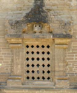 Perforated stone window and stone sculpture on the