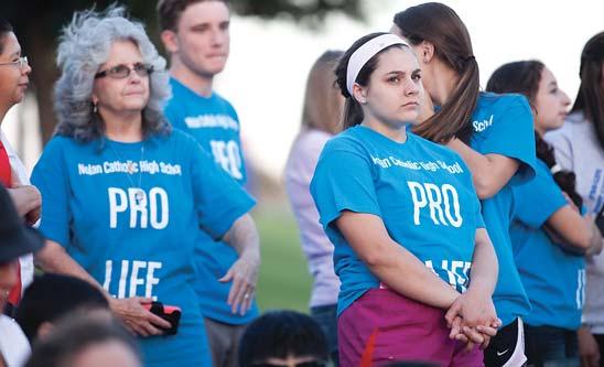Sarah Stehling (right), a sophomore involved in Nolan Catholic High School s Pro Life Club, listens to keynote speakers during the rally.