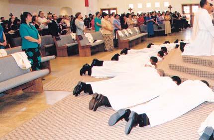 Deacons of the class of 2003 lie prostrate during the ordination rite at Holy Name Church in Fort Worth. Bishop Emeritus John McCarthy poses with the just-ordained deacons of the class of 2003.