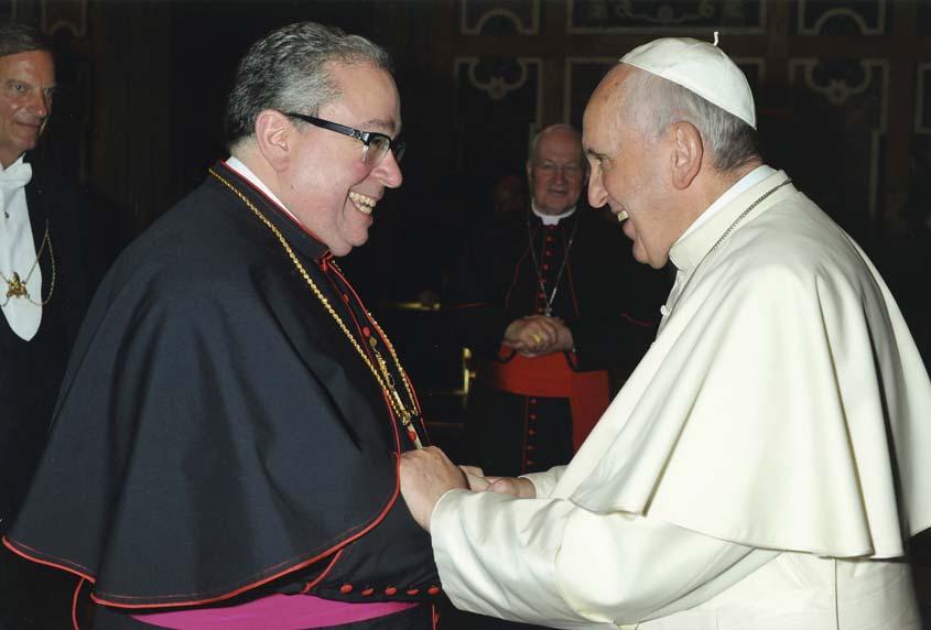 va Above: Bishop Michael Olson kisses Pope Francis ring as a sign of his union with and loyal obedience to the pope.