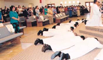 Los diáconos de la clase del 2003 se postran frente al altar durante el Rito de ordenación en la Parroquia del Santo Nombre en Fort Worth.