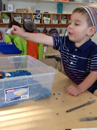 One ocean was filled with water, and the other with water accessories: Boats, shells, fish and play people. Shira picked up one of the toys, and correctly identified it as a "fishy." "What is this?