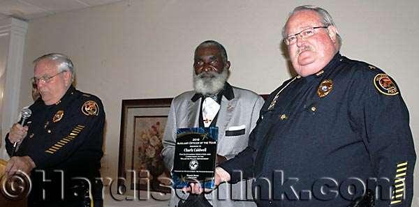 The Rev. Charlz Caulwell (center) {Some people spell his name differently, but he spells it as it is shown here.} AUXILIARY OFFICER OF THE YEAR The Rev.