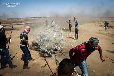 2 Right: Palestinian rioters drag away the barbed wire near the security fence east of Khan Yunis.