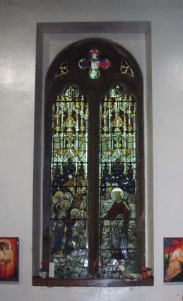 Stained glass depicting saints and a dove dedicated to Harriet Smithers