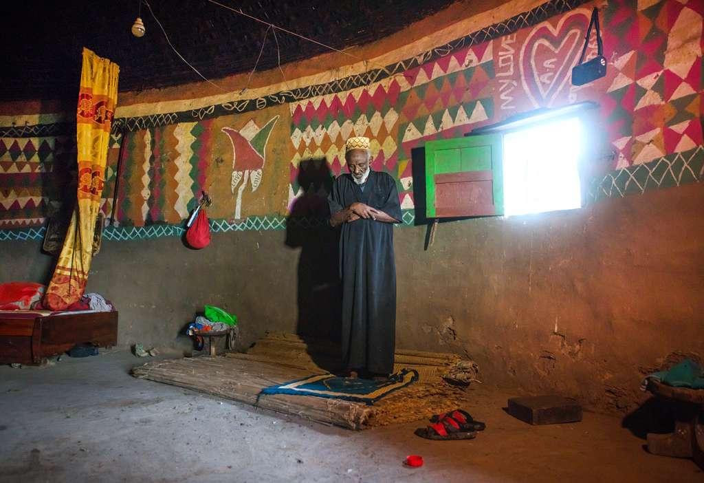 This Muslim man is praying inside his house.