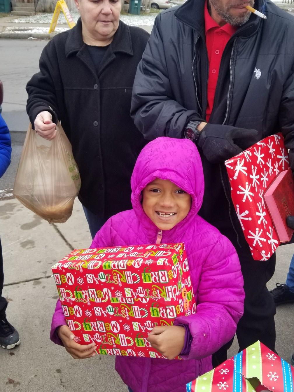 A child receives a donated Christmas gift at an outreach.