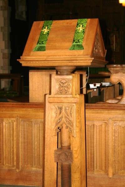 We sit while a reader (Lector/Lay Eucharistic Minister) stands at the Lectern, located on the right as you face the