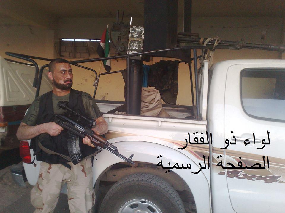 Figure 14: An LZ fighter poses with a technical (modified armed pickup truck).