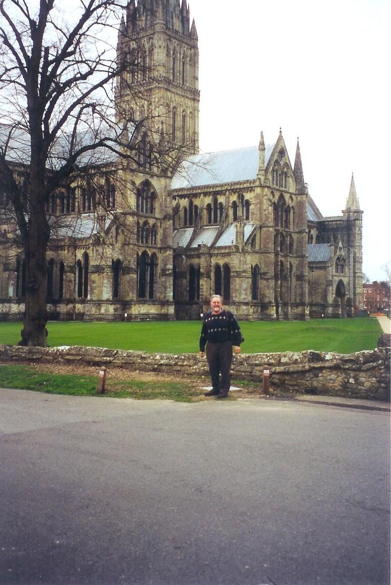 REV. JOHN STANDING by WELLS CATHEDRAL Here stands Wells Cathedral and John. To him, this was somehow like a home coming with his wife Martine.