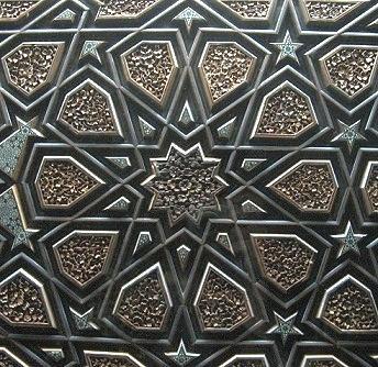 Quranic inscriptions are demonstrated as wood carving panels in various Arabic writing styles.