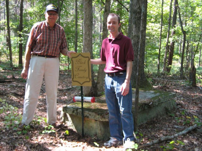 Glenn Paul and Michael Black stand beside a crypt at the Black Cemetery Jim Black